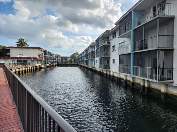 View of apartments with balconies built alongside a waterway.