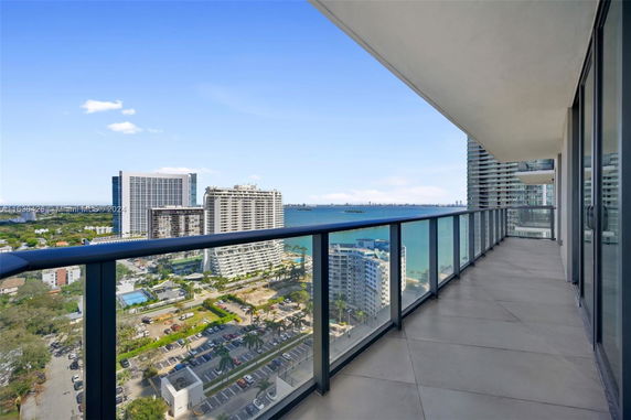 Wide balcony view of cityscape and waterfront area.