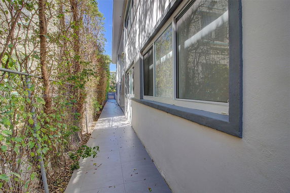 Side view of a building with windows and a paved walkway.