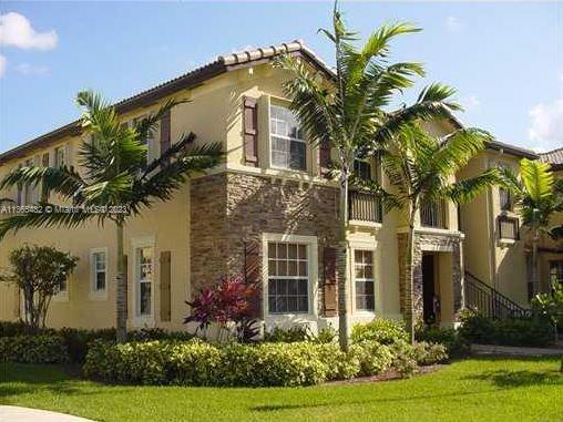 Front view of a two-story house with a stone facade and multiple windows.