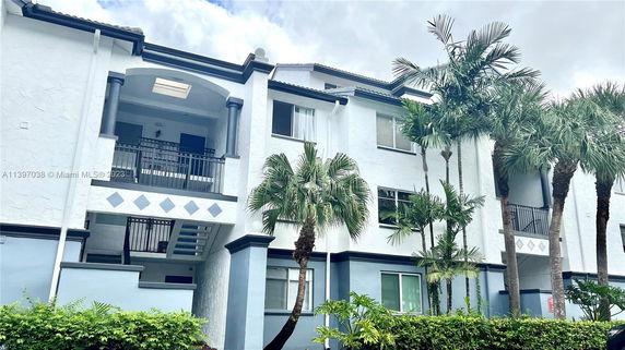 Front view of a multi-story building with balconies and windows.
