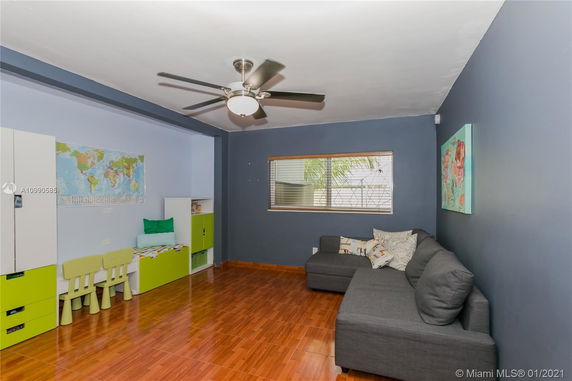Room with a sofa, children's furniture, and a world map on the wall.