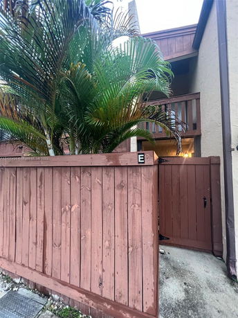 Front view of a two-story building with a wooden fence and balcony.