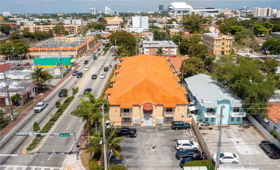Aerial view of an urban area featuring a long building with an orange roof.