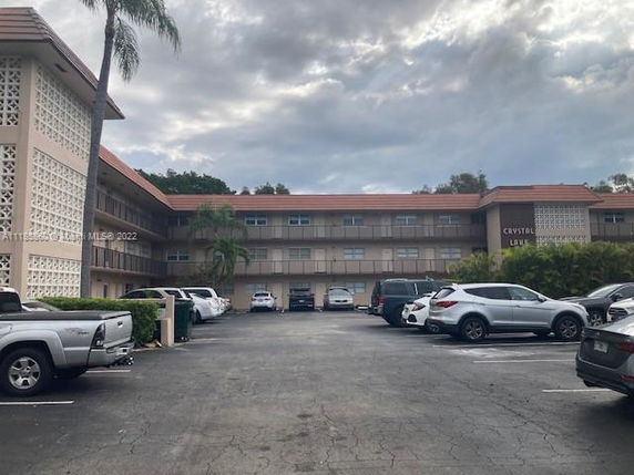 Front view of a multi-story building with parking area.