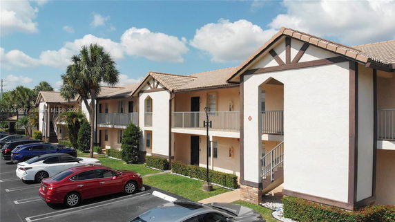 Front view of a two-story apartment building with a gabled roof and balconies.