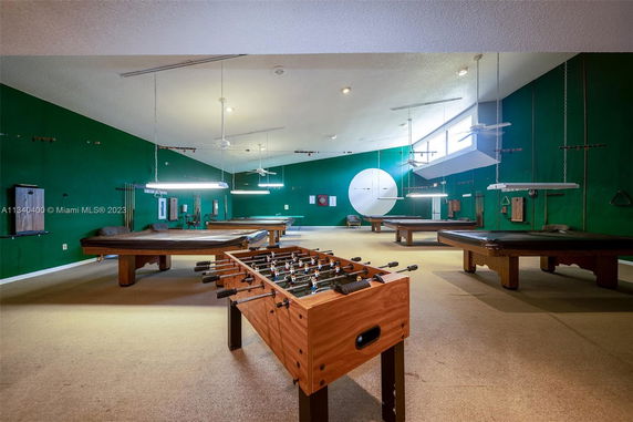 Indoor recreational area with billiards and foosball tables.