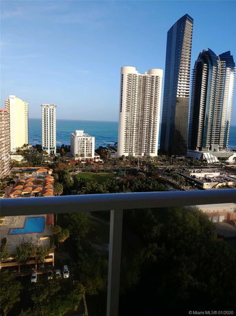 View of tall buildings and the ocean from a high vantage point.