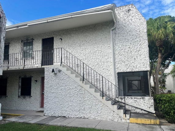 Front view of a two-story building with external staircase.