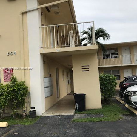 Front view of a two-story apartment building with balconies.