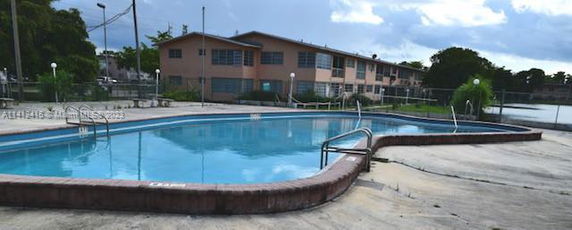 Outdoor swimming pool in front of a residential building.