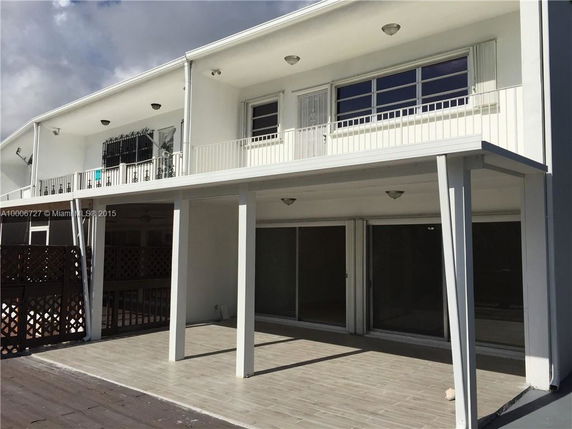 Front view of a two-story house with a balcony and covered patio area.