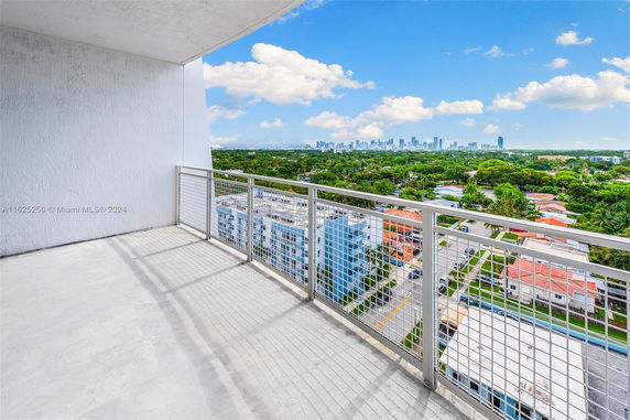 Balcony with a panoramic view of surrounding cityscape and greenery.