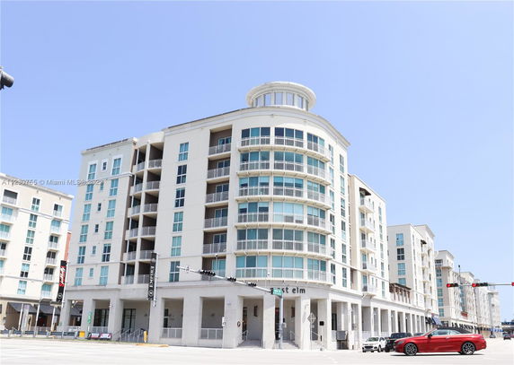 Front view of a multi-story building with balconies and large windows.