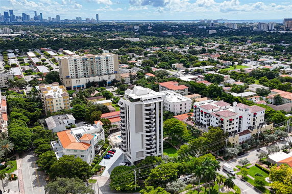 Aerial view of urban area with residential buildings and a city skyline in the distance.