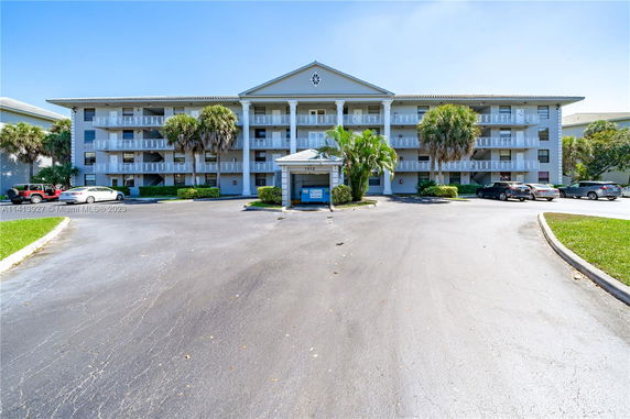 Front view of a three-story apartment building with balconies.