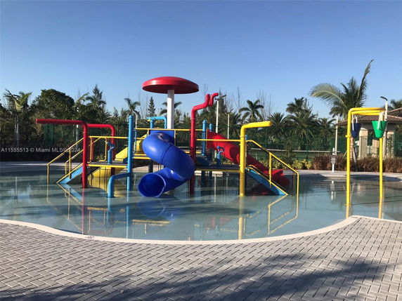 Outdoor water play area with slides and fountains.