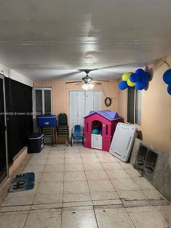 Indoor area with tiled floor and children's playhouse.