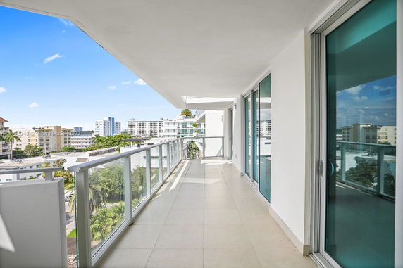 Balcony with glass railing overlooking an urban area.