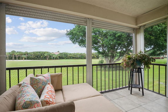 Balcony view overlooking a lawn and trees.