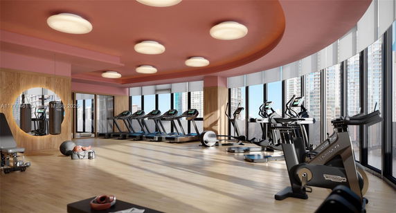 Interior view of a gym with exercise equipment and large windows.