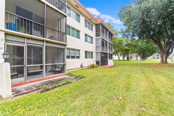 Side view of a multi-story residential building with screened balconies.