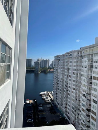 View of waterfront buildings with a river and high-rise apartments in the background.
