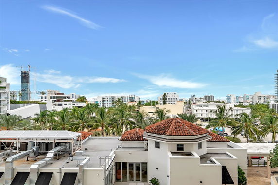 Panoramic view of cityscape with buildings and palm trees.