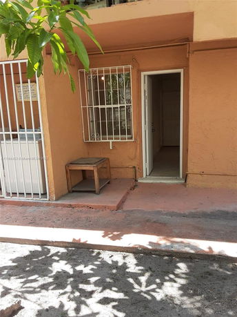 Front view of a building with a small entrance and barred windows.