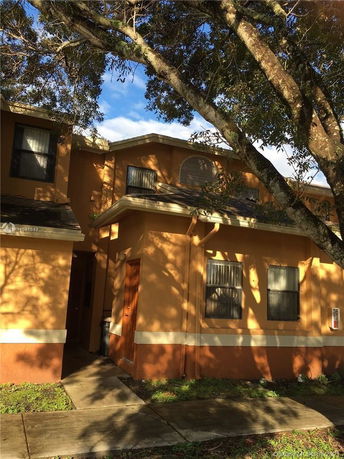 Front view of a two-story house with a sloped roof and multiple windows.