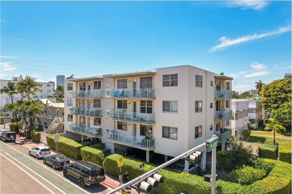 Front view of a multi-story apartment building with balconies.