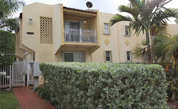 Front view of a two-story building with a balcony and lattice wall in a residential area.