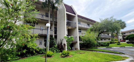 Front view of a three-story apartment building with balconies.