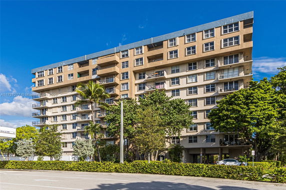 Front view of a multi-story apartment building with balconies.