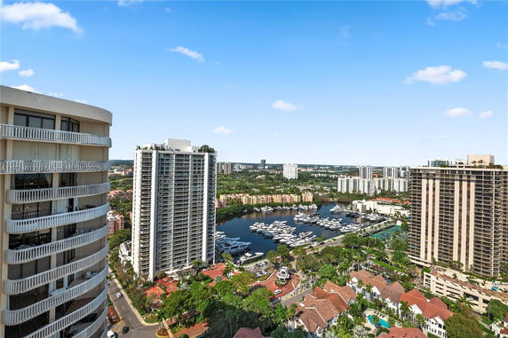 Panoramic view of high-rise buildings and a marina with boats.