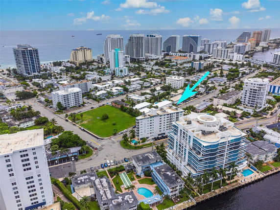 Panoramic aerial view of a coastal cityscape with multiple buildings and the ocean in the background.