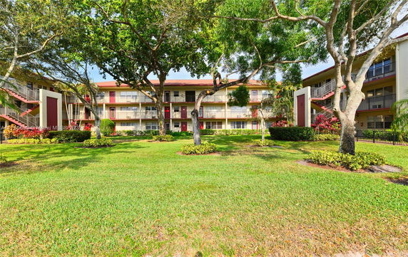 Front view of a multi-story residential building with balconies and exterior stairs.