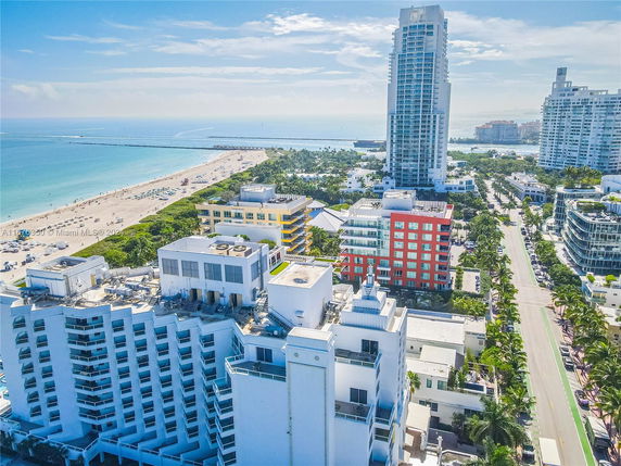 Aerial view of a beachfront cityscape with tall buildings and coastline.