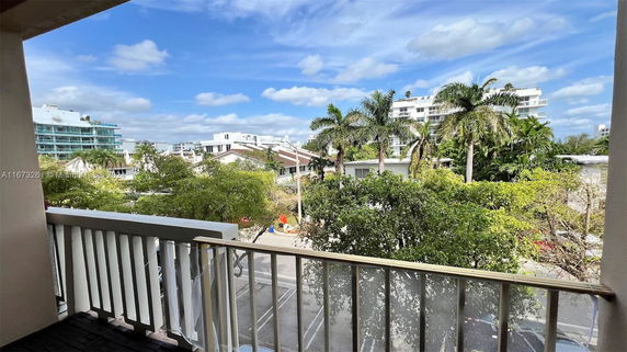 View from a balcony overlooking surrounding buildings and trees.