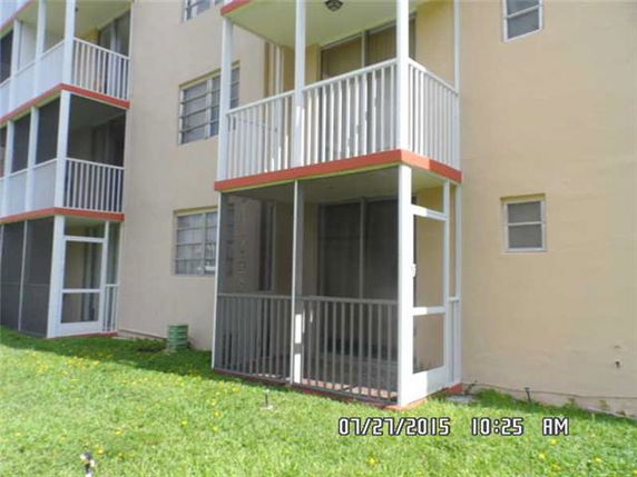 Front view of an apartment building with balconies and screened patios.