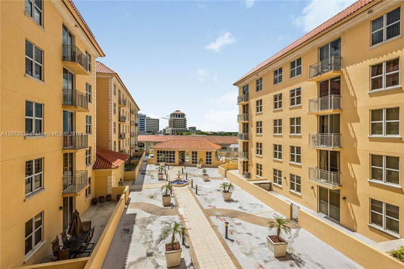 View between two multi-story buildings with a central courtyard area.