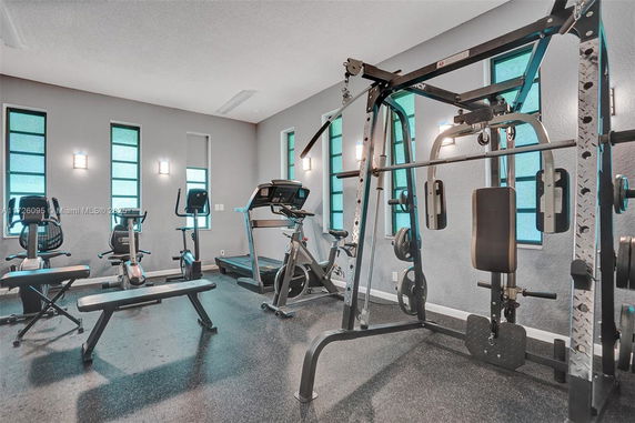 Indoor gym area with exercise machines and equipment.