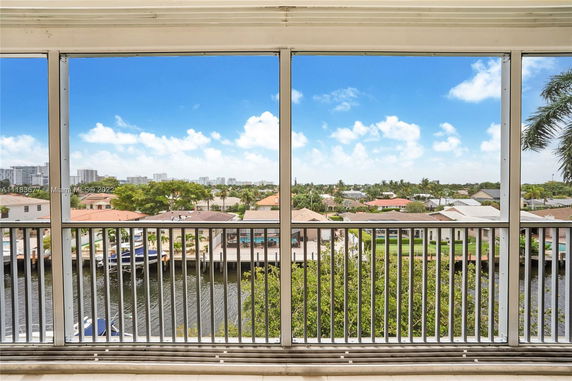 Panoramic view of residential area with canal and distant buildings from a high vantage point.