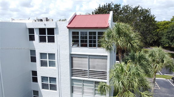 Front view of a multi-story building with red roof tiles and large windows.
