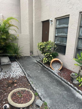 Front view of a house entrance with a pathway and plants.