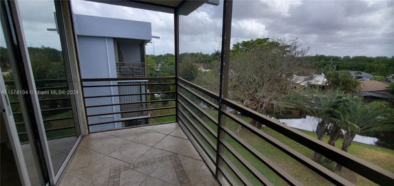View from a balcony overlooking nearby houses and greenery.