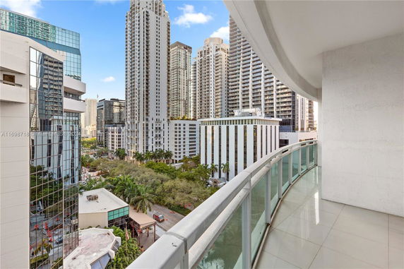 View from a balcony showing tall skyscrapers and a cityscape.