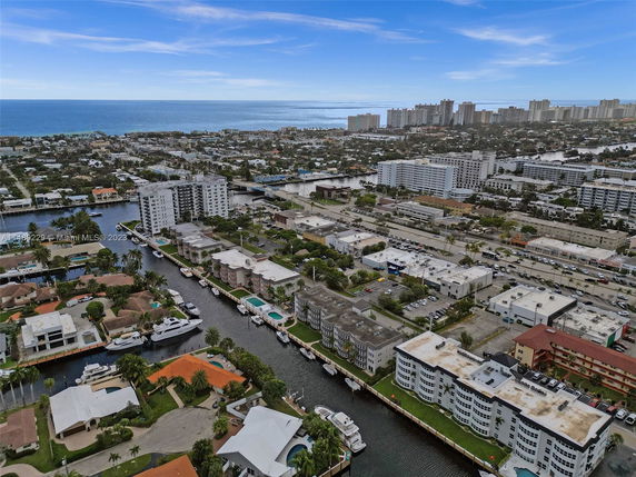 Aerial view of a coastal city with waterways and buildings, leading to the ocean.