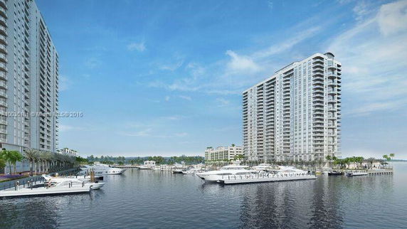 View of waterfront high-rise residential buildings with boats docked on the water.