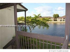 View from a balcony overlooking a water body and nearby houses.